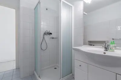 a white bathroom with a shower and a sink at Spacious Studio Apartment Near The Beach - 2313 in Cannes