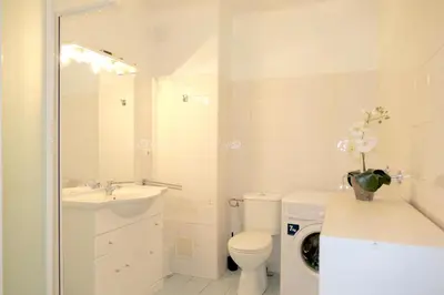 a bathroom with a toilet sink and a washing machine at Spacious Studio Apartment Near The Beach - 2313 in Cannes