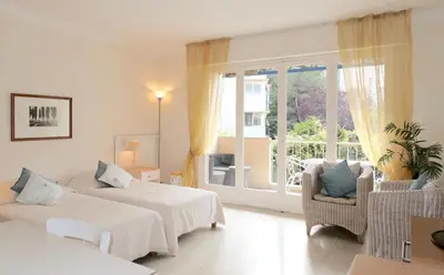 a white room with two beds and a window at Spacious Studio Apartment Near The Beach - 2313 in Cannes