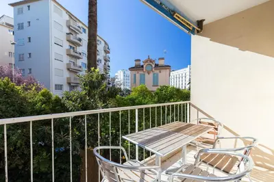 a table and chairs on a balcony with a building at Spacious Studio Apartment Near The Beach - 2313 in Cannes