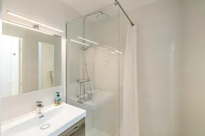 a white bathroom with a sink and a shower at Charming flat with sea view - 1BR - 2P - Cannes in Cannes