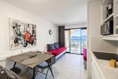 a living room with a table and a red couch at Charming flat with sea view - 1BR - 2P - Cannes in Cannes