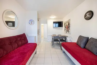 a living room with a red couch and a table at Charming flat with sea view - 1BR - 2P - Cannes in Cannes