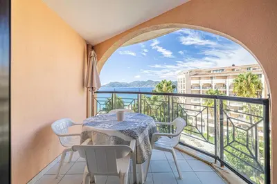 a table and chairs on a balcony with a view of the ocean at Charming flat with sea view - 1BR - 2P - Cannes in Cannes