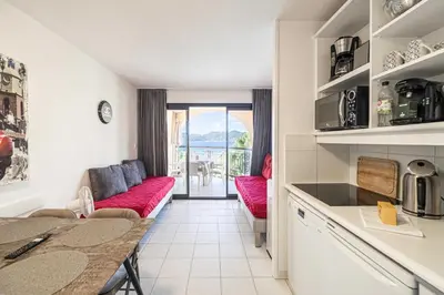 a living room with a red couch and a table at Charming flat with sea view - 1BR - 2P - Cannes in Cannes