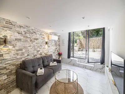a living room with a couch and a brick wall at Modern a c apartment 2BR 8P - Cannes in Cannes