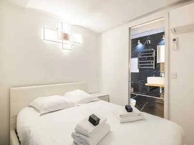a white bedroom with a bed with towels on it at Modern a c apartment 2BR 8P - Cannes in Cannes