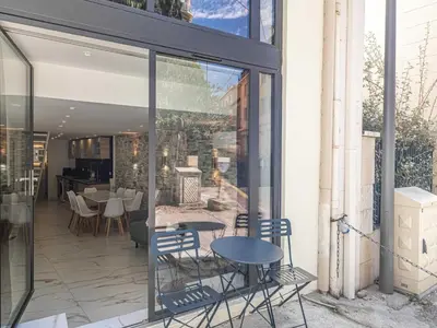 a patio with glass doors and chairs and a table at Modern a c apartment 2BR 8P - Cannes in Cannes