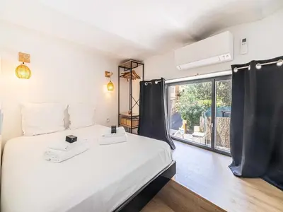 a bedroom with a bed and a large window at Modern a c apartment 2BR 8P - Cannes in Cannes