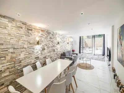 a dining room with a stone wall and a table and chairs at Modern a c apartment 2BR 8P - Cannes in Cannes