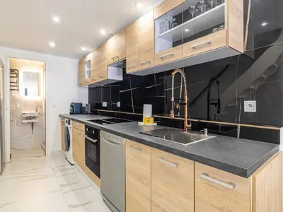 a kitchen with wooden cabinets and a sink at Modern a c apartment 2BR 8P - Cannes in Cannes