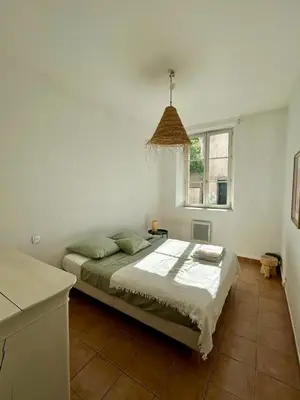 a bedroom with a bed and a window at Large duplex with garden in historic house in Le Cannet