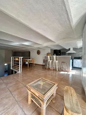 a living room with a table on a tile floor at Large duplex with garden in historic house in Le Cannet