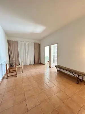 an empty living room with a bench and a table at Large duplex with garden in historic house in Le Cannet