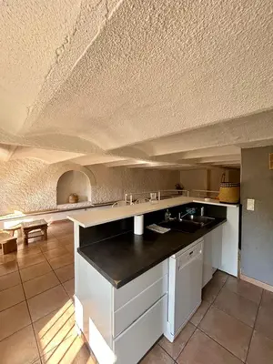a kitchen with white cabinets and a white ceiling at Large duplex with garden in historic house in Le Cannet