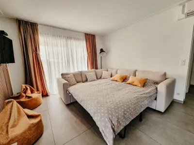 a living room with a couch in front of a window at Appartement centre Cannes Soleil - 2 rooms in Cannes
