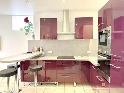 a kitchen with purple cabinets and a counter with stools at Cannes centre T3 Carré D'Or calme air conditionné WiFi in Cannes