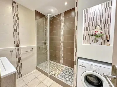 a washing machine in a bathroom with a shower at Cannes centre T3 Carré D'Or calme air conditionné WiFi in Cannes
