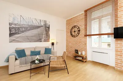 a living room with a couch and a clock on the wall at Appartement centre-ville à 5 min du palais des festivals in Cannes