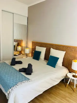 a bedroom with a large white bed with blue pillows at Appartement centre-ville à 5 min du palais des festivals in Cannes
