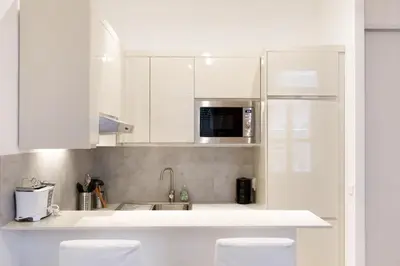 a kitchen with white cabinets and a sink at Appartement centre-ville à 5 min du palais des festivals in Cannes