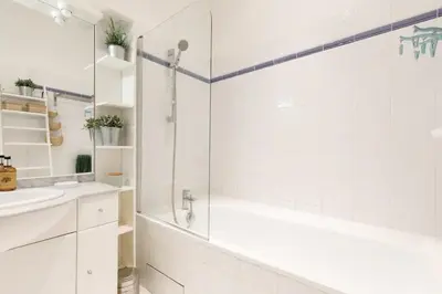 a white bathroom with a shower and a sink at Appartement centre-ville à 5 min du palais des festivals in Cannes