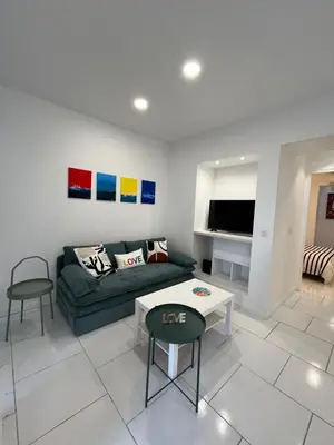 a living room with a couch and a table at La petite MAISON BLANCHE CANNES in Cannes