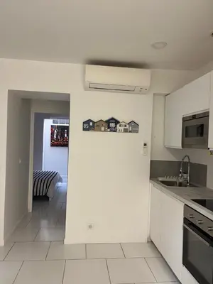 a kitchen with white cabinets and a stove top oven at La petite MAISON BLANCHE CANNES in Cannes