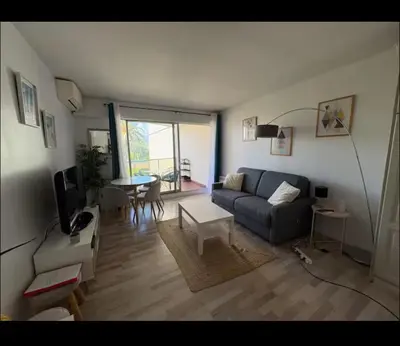 a living room with a couch and a table at Terrasse Clim Wifi Parking 10 min à pieds de la Croisette in Cannes