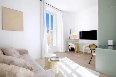 a white living room with a couch and a table at Les Lucioles 3 - Luxury Studio Apartment in Cannes