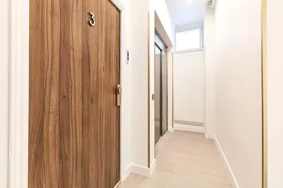 a hallway with a wooden door and a window at Les Lucioles 3 - Luxury Studio Apartment in Cannes