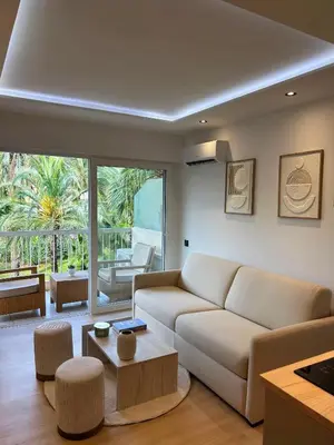 a living room with a couch and a table at Charmant studio avec grande terrasse in Cannes