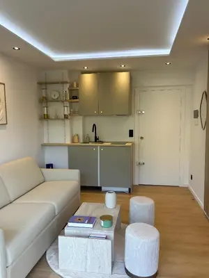 a living room with a white couch and a kitchen at Charmant studio avec grande terrasse in Cannes