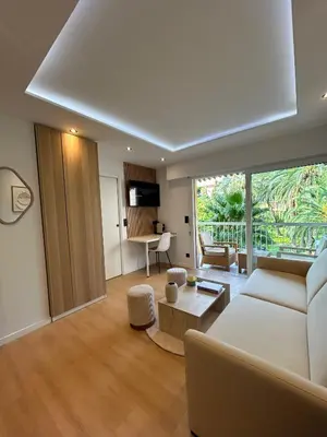 a living room with a couch and a table at Charmant studio avec grande terrasse in Cannes