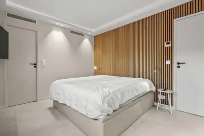 a bedroom with a bed and a wooden wall at REF 2021 -Cannes Centre Croisette - Apartment for rent in Cannes