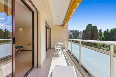 a balcony with a view of a living room at REF 2021 -Cannes Centre Croisette - Apartment for rent in Cannes