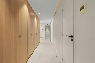 a hallway with white walls and wooden cabinets at REF 2021 -Cannes Centre Croisette - Apartment for rent in Cannes