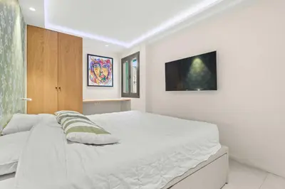a white bedroom with a large white bed in it at REF 2021 -Cannes Centre Croisette - Apartment for rent in Cannes