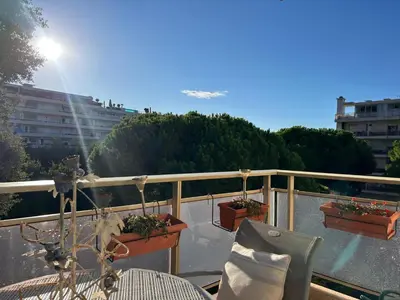 a balcony with a table and chairs and plants at Cozy Cannes Studio - 12 Min Walk To The Beach - Free Parking in Cannes