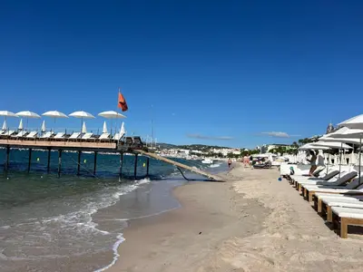 a pier with chairs on the beach next to the ocean at Cozy Cannes Studio - 12 Min Walk To The Beach - Free Parking in Cannes