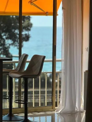 a room with a balcony with a view of the ocean at Luxury Apartment with Sea View and Private Beach Access in Cannes