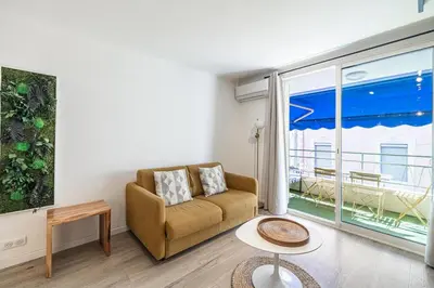 a living room with a couch and a large window at 13 PRAD - Renovated apartment for 3 travelers near Croisette in Cannes