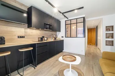a kitchen with black cabinets and a counter top at 13 PRAD - Renovated apartment for 3 travelers near Croisette in Cannes
