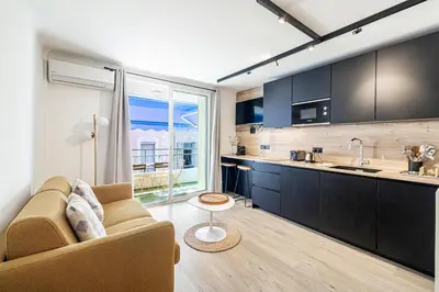 a living room with a couch and a kitchen at 13 PRAD - Renovated apartment for 3 travelers near Croisette in Cannes