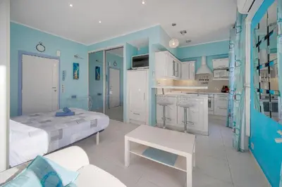 a blue and white room with a bed and a kitchen at Studio Cannes Centre 2 min from La Croisette in Cannes
