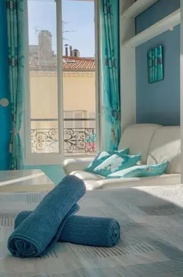 a bed with a blue towel on top of it at Studio Cannes Centre 2 min from La Croisette in Cannes