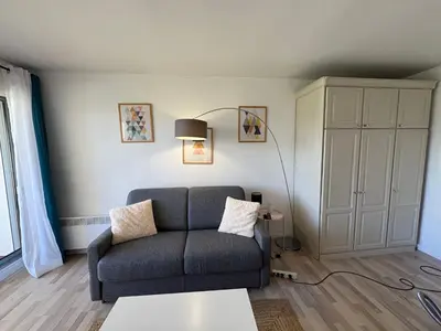 a living room with a couch and a table at Studio lumineux, terrasse, clim, parking, centre ville in Cannes