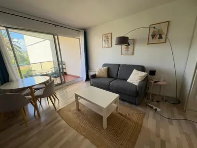 a living room with a couch and a table at Studio lumineux, terrasse, clim, parking, centre ville in Cannes
