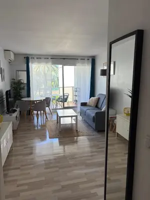 a living room with a couch and a table at Studio lumineux, terrasse, clim, parking, centre ville in Cannes