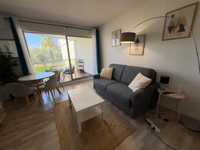 a living room with a couch and a table at Studio lumineux, terrasse, clim, parking, centre ville in Cannes